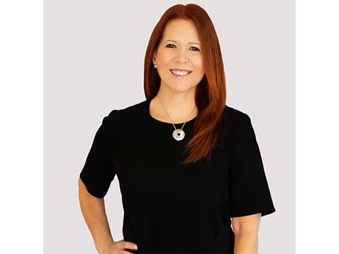 A portrait of a smiling woman wearing a black top