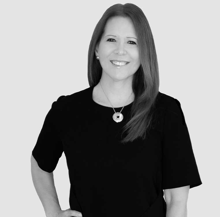 A portrait of a smiling woman wearing a black top